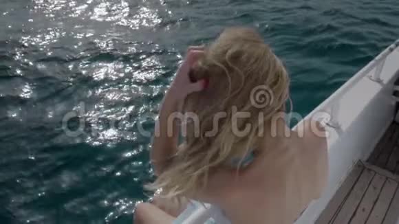 穿比基尼的白种人女孩的肖像和海洋游艇甲板上的太阳镜他玩弄着头发视频的预览图