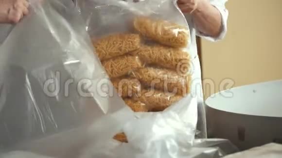 一家面食厂工人从传送带上包装通心粉视频的预览图