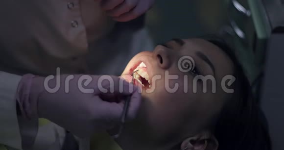 年轻女子正张着嘴坐在牙科椅上视频的预览图