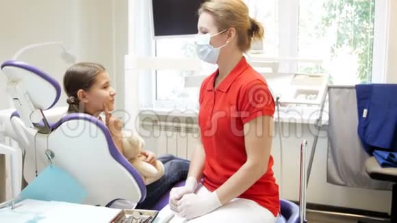 女牙医检查少女牙齿的4k镜头视频的预览图