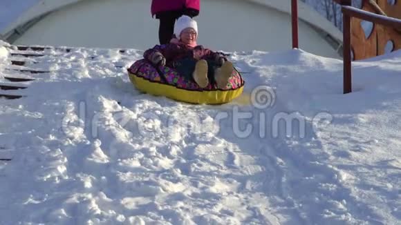 下面的动作女孩卷在一个托博根运行的雪橇油管3这个孩子冬天喜欢下坡视频的预览图