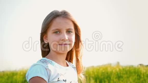有魅力的小女孩的肖像有一双绿色的大眼睛在大自然的背景下头发正在发育视频的预览图