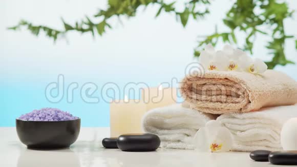 芳香疗法东方按摩和水疗毛巾蜡烛花石头和草药的放松成分视频的预览图