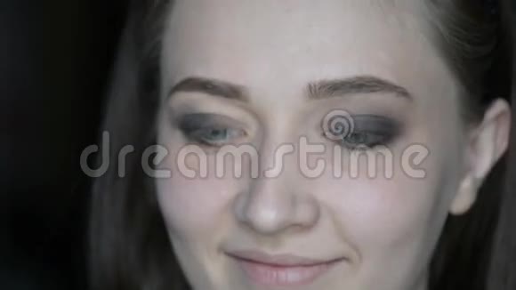 特写化妆师在模特儿的眼睛和眉毛上化妆绿色文印上一个红色成熟番茄的化妆马克罗形象视频的预览图