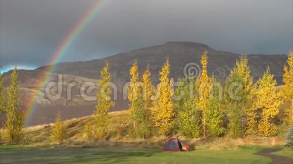 寒冷的橙色秋雾带着彩虹和帐篷在山上视频的预览图