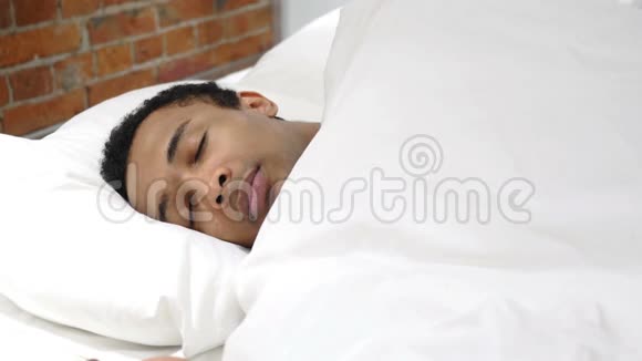 噩梦沉睡的非洲男人被可怕的梦惊醒视频的预览图