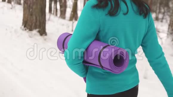 有瑜伽垫的女孩为冬天慢舞视频的预览图