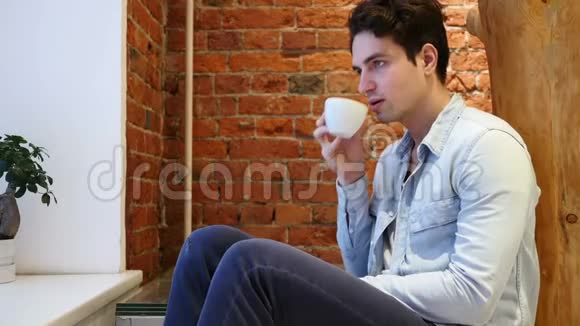 性感的年轻人喝杯咖啡洛夫特内部视频的预览图