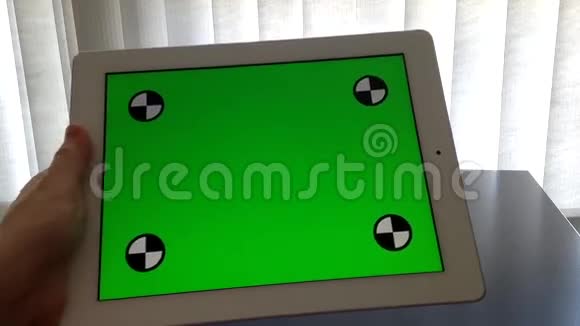 一位女士拿着绿色屏幕的数字平板电脑视频的预览图