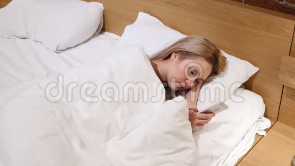 女人躺在床上用智能手机浏览视频的预览图