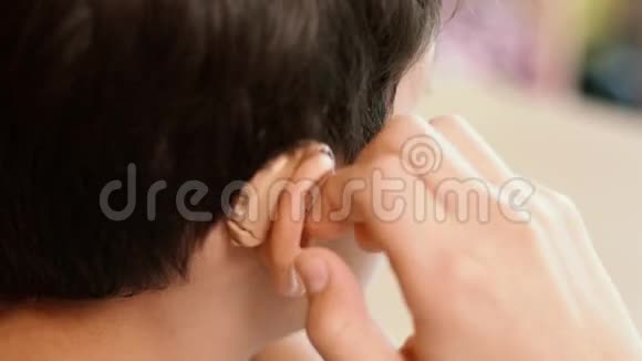 年轻人把助听器移开放在桌子上后来他用助听器视频的预览图