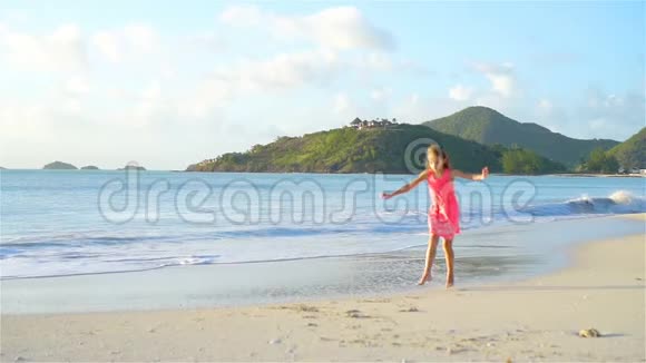 日落时在海滩上散步的小女孩的小寿星视频的预览图