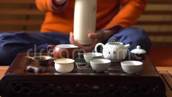 在传统的中国茶道中人们在茶壶里浇开水一套茶饮设备视频的预览图