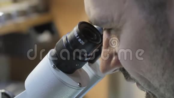 透过显微镜看医生透过显微镜看科学家通过显微镜观察主人视频的预览图