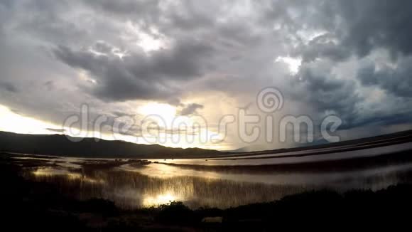 日落时云层移动的时间在湖景上流逝乡村有雨和风暴背景视频的预览图