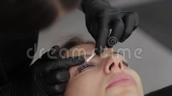 美容院的专业美容师给顾客画睫毛视频的预览图