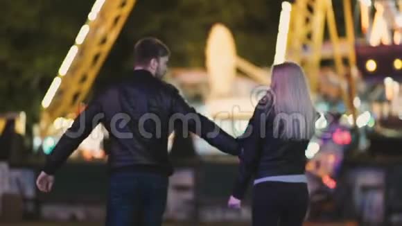 漂亮的情侣晚上在游乐园约会视频的预览图
