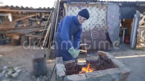 年轻的铁匠工作金属工匠村里私人铁匠铺的高地人在铁匠身上烧木头视频的预览图