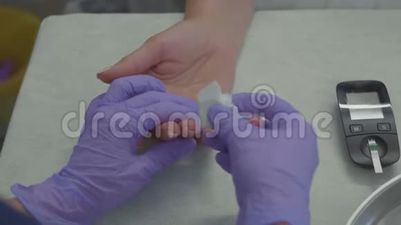 医生双手戴手套对女性病人进行指血试验视频的预览图