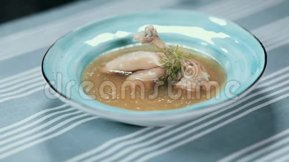 把食物夹起来餐厅做饭蓝色盘子里的汤鸡腿饺子和绿叶厨师变成了视频的预览图