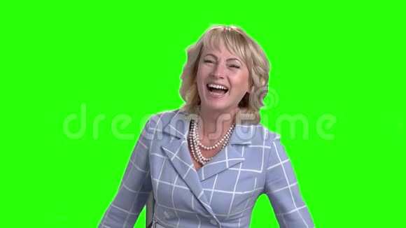 成熟的女人在绿色的屏幕上笑视频的预览图