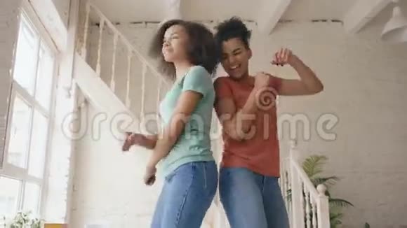 混合种族的年轻美丽的姐妹在床上跳舞一起在家里的卧室里玩得开心视频的预览图