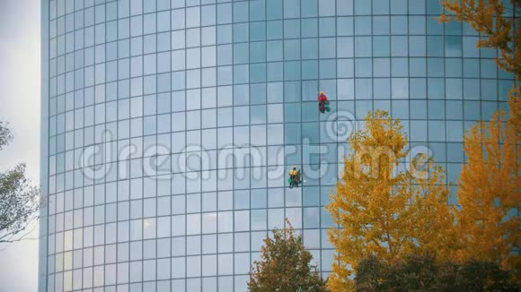两名工人在打扫一座摩天大楼的窗户工业上的泛黄视频的预览图