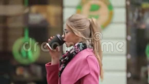 漂亮的年轻女子穿着时尚的服装匆忙地喝着咖啡市中心商务小姐很忙芳香族视频的预览图