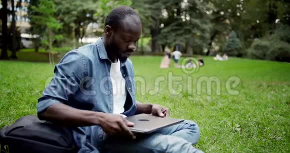非裔美国男性公园里有笔记本电脑视频的预览图