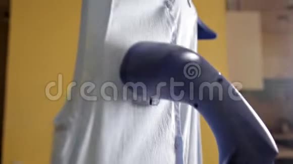 女人用蒸汽熨她的衬衫用蒸汽清洁剂蒸衬衫的过程关门视频的预览图