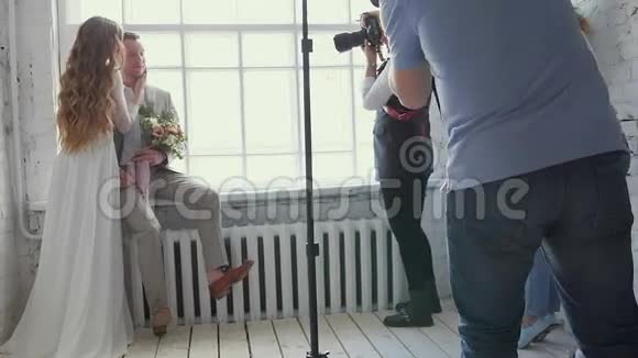 一对新郎新娘在大师班为摄影师摆姿势模型进行拍照贝克阶段视频的预览图