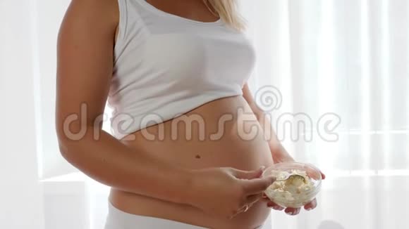 有大裸肚子的女人拿着一盘白奶酪酸牛奶视频的预览图