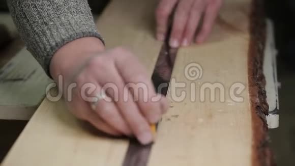木工在切割木板前用尺量视频的预览图