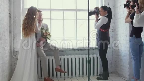 一对新郎新娘在大师班为摄影师摆姿势模型进行拍照贝克阶段视频的预览图
