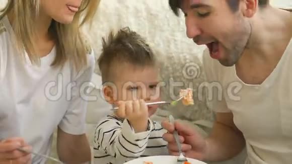小可爱的男孩庆祝生日给爸爸和妈妈吃蛋糕视频的预览图