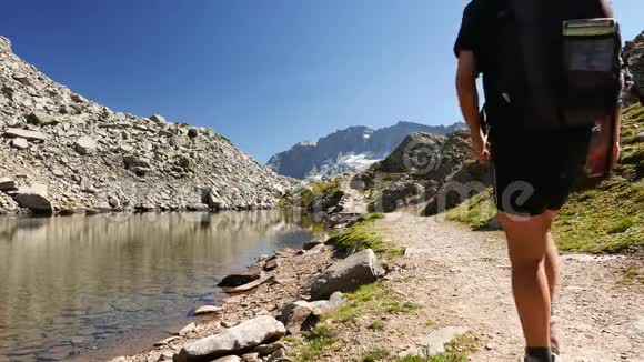 两人在田园诗般的山景中徒步旅行有水晶湖高山峰和冰川夏日冒险视频的预览图