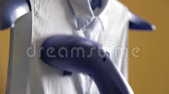 女人用蒸汽熨她的衬衫用蒸汽清洁剂蒸衬衫的过程关门视频的预览图