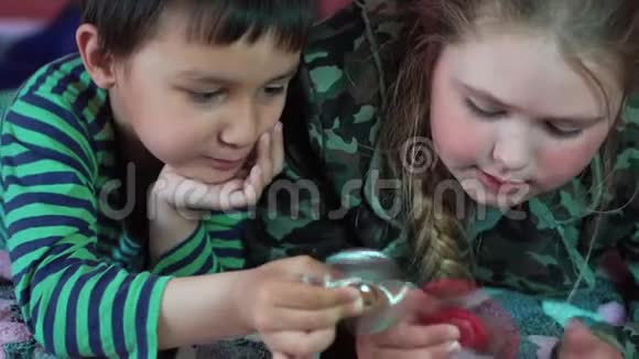 金发白种人女孩和一个多民族男孩在家玩旋转玩具4K视频的预览图