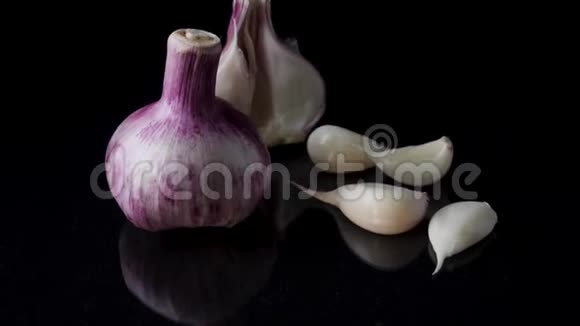 洋葱和大蒜在黑色背景上洋葱和大蒜在黑色背景下的残留视频的预览图