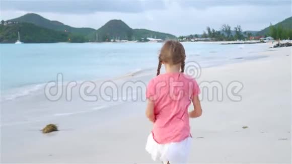 日落时在海滩上散步的小女孩的小寿星视频的预览图