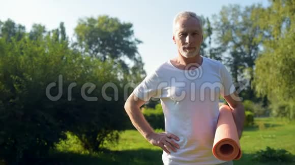 英俊的老人在公园里锻炼身体视频的预览图