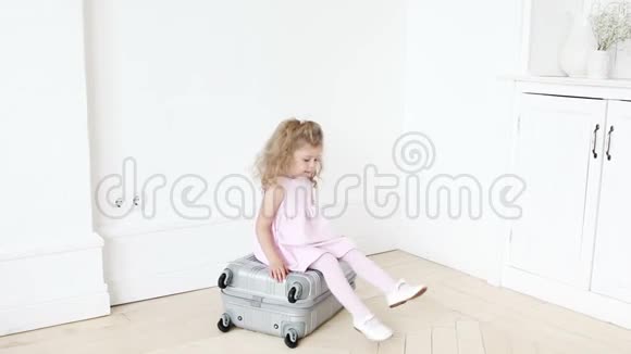 坐在行李上嬉戏的女孩视频的预览图