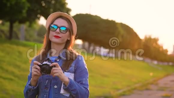 女孩正在绕着城市走来走去在电影摄像机上拍摄自然和风景慢动作视频的预览图