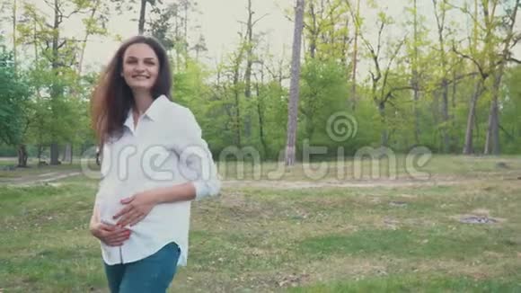 抱着肚子在夏天散步的孕妇视频的预览图