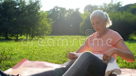 在公园运动后休息的漂亮的老年妇女视频的预览图