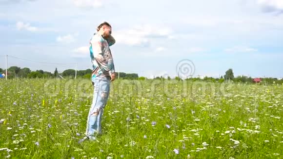 时髦留胡子的人在绿色的田野里散步视频的预览图