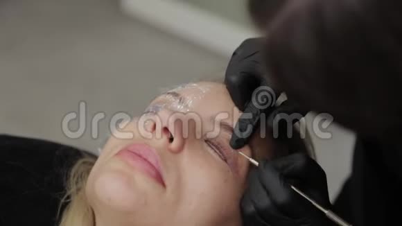 美容院的专业美容师给顾客画睫毛视频的预览图