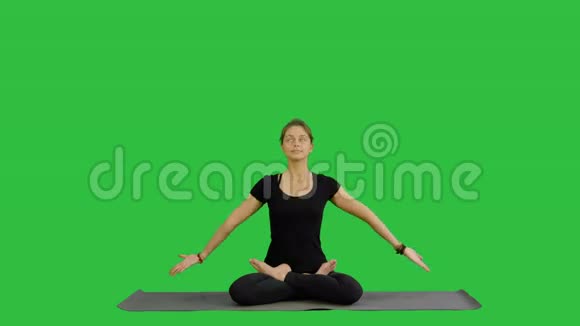 女人在莲花姿势中练习瑜伽用绿色屏幕上的Namaste手势Chroma键视频的预览图