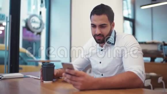 神奇的人拿着一杯咖啡微笑着走向手机屏幕日常生活社交网络使用视频的预览图