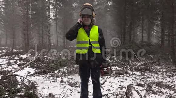 暴风雪中拿着电锯的伐木工人在打电话视频的预览图